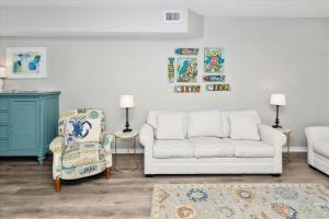 sala de estar con sofá y silla en Sandpiper Cove #9124 Condo, en Destin