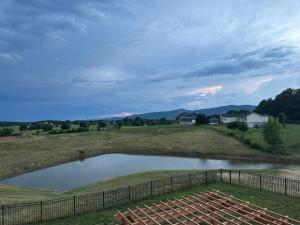 a small pond in a field with a fence at Sunset Haven in Front Royal