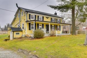 a yellow house with a black roof at Wantage Getaway with Private Pickleball Court! in Wantage