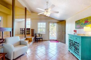 a living room with a ceiling fan and a chair at Sandy Feats in Gulf Highlands