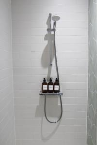 a shower with two bottles of wine on a shelf at New, Luxury Apartment in Town Centre in Cheltenham