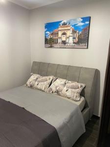 a bed in a bedroom with a picture on the wall at Mrassi in Palermo
