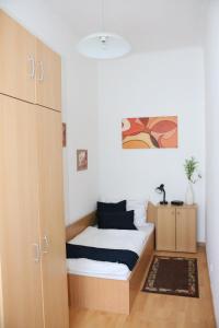 une petite chambre avec un lit et une armoire dans l'établissement Residenz Johann Strauss, à Vienne
