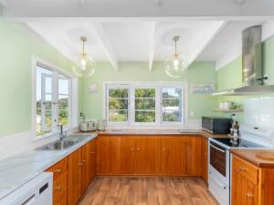 Kitchen o kitchenette sa Crabapple Cottage - Coromandel Town Holiday Home