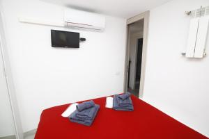 - une chambre avec un lit rouge et des serviettes dans l'établissement Gianicolo House, à Rome