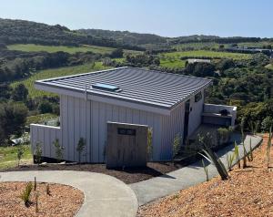 um edifício com um telhado solar em cima dele em 125 Church Bay Cabins em Oneroa