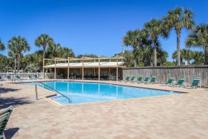 a swimming pool with chairs and a building at Seascape Golf Villas 95E in Destin