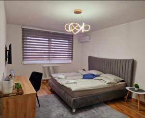 een slaapkamer met een bed en een kroonluchter bij Infinity Apartment & Free Wifi & Free Parking in Sarajevo