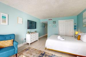 ein Schlafzimmer mit einem Bett und einer blauen Wand in der Unterkunft Islander W 703 in Fort Walton Beach