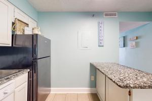 a kitchen with a refrigerator and a counter top at Islander W 703 in Fort Walton Beach