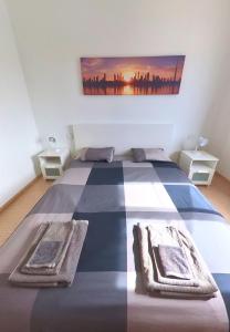 Casa Mic&ele في بلايا بلانكا: غرفة نوم بسرير مع لوحة على الحائط
