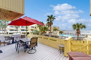 a patio with a table and chairs and an umbrella at Buena Vida 17 in Navarre