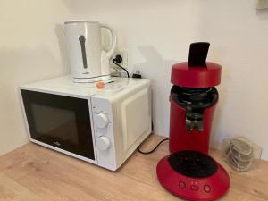 un forno a microonde e una macchina per il caffè accanto a un frullatore di Appart 41 Montbéliard: calme et cosy + piscine a Sainte-Suzanne