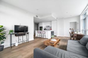 uma sala de estar com um sofá e uma mesa em Urban Oasis: Stylish Apartment Retreat at UBC em Vancouver
