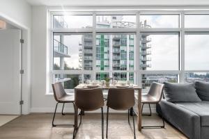 - une salle à manger avec une table, des chaises et un canapé dans l'établissement Urban Oasis: Stylish Apartment Retreat at UBC, à Vancouver