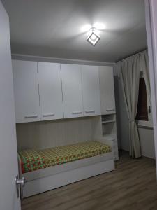 Zimmer mit weißen Schränken und einem Bett. in der Unterkunft Casa Seamus Briatico in Briatico