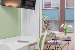Habitación con escritorio blanco y ventana. en Residenze Asproni Serviced Apartments en Cagliari