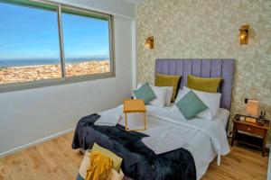 a bedroom with a large bed with a large window at Rabat vue du ciel, majestueux et panoramique centre ville in Rabat