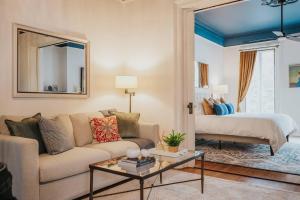 uma sala de estar com um sofá e uma cama em Charming Historic District Parlor Level Apartment em Savannah