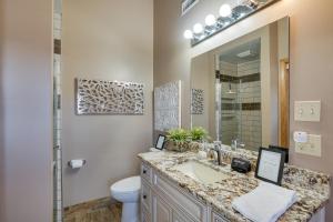 a bathroom with a sink and a toilet and a mirror at Private Dock Lakefront Sunrise Beach Home in Sunrise Beach +18 photos
