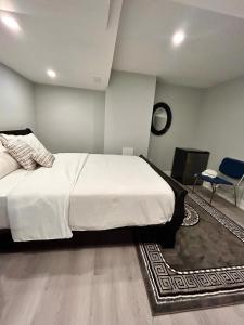 1 dormitorio con 1 cama blanca grande y 1 silla en APARTMENT B 2 BEDROOM en Brampton