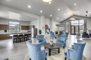 sala de estar con sillas azules y cocina en Marana Home with Pool Access and Mountain Views!, en Marana