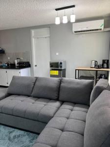 um sofá cinzento numa sala de estar com uma cozinha em Panorama Ochi - Sand Castles Resort B20 em Ocho Rios