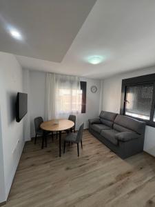 - un salon avec un canapé et une table dans l'établissement AB Apartamentos, à Melilla