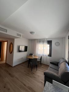 ein Wohnzimmer mit einem Sofa und einem Tisch in der Unterkunft AB Apartamentos in Melilla
