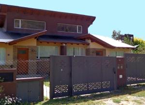 a house with a gate and a fence at Casa con vista al Piltri in El Bolsón