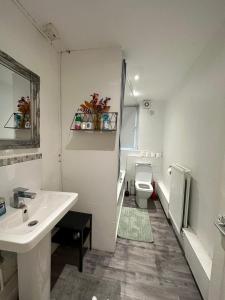 uma casa de banho branca com um lavatório e um WC em 2 bedroom flat, 2 minutes walk to Bethnalgreen station, Central London em Londres
