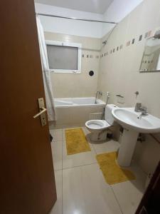 La salle de bains est pourvue d'un lavabo, de toilettes et d'une baignoire. dans l'établissement Villa spacieuse et agréable, à Dakar