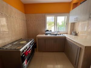 Il comprend une petite cuisine équipée d'une cuisinière et d'un évier. dans l'établissement Villa spacieuse et agréable, à Dakar