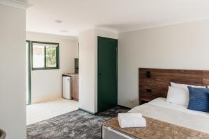a bedroom with a large bed and a green door at Wallaby Hotel in Gold Coast