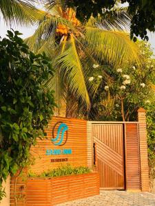 a wooden gate with a sign for a gate inn at Sand Inn Residence in Kamadhoo