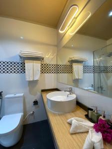 Kamadhoo的住宿－Sand Inn Residence，带浴缸、盥洗盆和卫生间的浴室