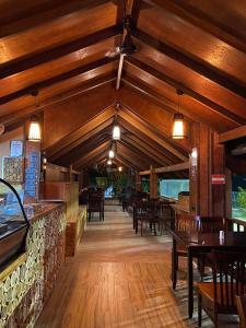 a restaurant with wooden ceilings and wooden tables and chairs at Sand Inn Residence in Kamadhoo