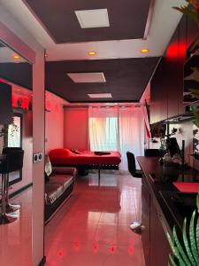 a red living room with a couch and a bed at C12 Deluxe in Cap d'Agde