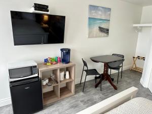 a living room with a small table and a tv at Cheticamp Outback Inn in Chéticamp