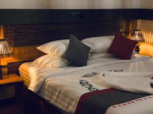 a large bed with pillows on top of it at Sand Inn Residence in Kamadhoo