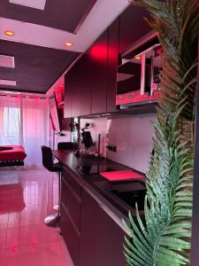 a kitchen with red lighting and a black counter top at C12 Deluxe in Cap d'Agde