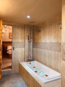a bathroom with a bath tub and a bedroom at Sand Inn Residence in Kamadhoo