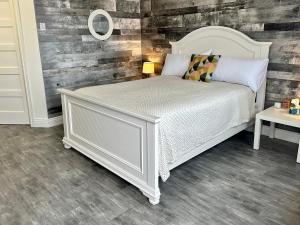 um quarto com uma cama branca e uma parede de madeira em Cheticamp Outback Inn em Chéticamp