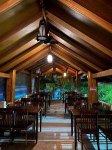 a dining room with wooden tables and chairs at Sand Inn Residence in Kamadhoo