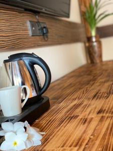 a tea kettle and a cup on a wooden table at Sand Inn Residence in Kamadhoo +21 photos