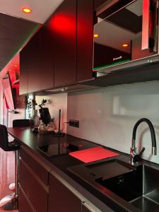 a kitchen with black counter tops and red cabinets at C12 Deluxe in Cap d'Agde