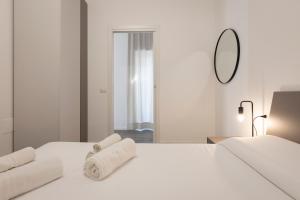 een slaapkamer met een wit bed en handdoeken bij Lucana Rooftop in Matera