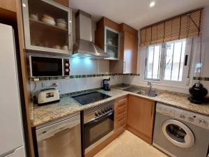 a kitchen with a sink and a stove top oven at Apartamento Neptuno Sunrise Magic World in Oropesa del Mar