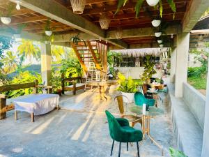 patio ze stołami i krzesłami oraz schodami w obiekcie Bintana sa Paraiso Binunsaran w Mambajao