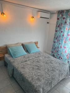 a bedroom with a bed with blue pillows at Beautiful Day Studio in Les Trois-Îlets